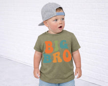Load image into Gallery viewer, A young child wearing a gray baseball cap and a green t-shirt with the text "BIG BRO" printed on it, standing in front of a white brick wall.