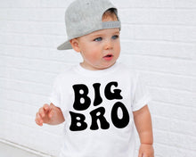 Load image into Gallery viewer, A young child wearing a white t-shirt with the text "BIG BRO" printed on it, standing in front of a white brick wall.