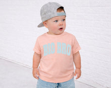 Load image into Gallery viewer, A young child wearing a gray baseball cap and a pink t-shirt with the text "BIG BRO" standing in front of a white brick wall.