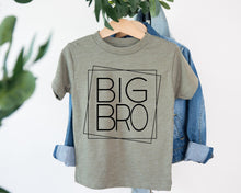 Load image into Gallery viewer, A gray t-shirt with the text "BIG BRO" printed on it, hanging on a wooden hanger.