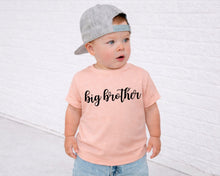 Load image into Gallery viewer, A young child wearing a gray baseball cap and a pink t-shirt with the text "big brother" printed on it, standing in front of a white brick wall.