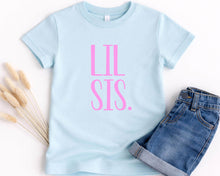 Load image into Gallery viewer, A light blue t-shirt with the text "LIL SIS" printed in pink letters, along with a pair of denim shorts, are displayed on a white background.
