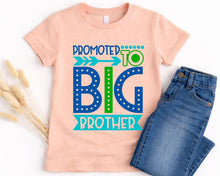 Load image into Gallery viewer, A pink t-shirt with a graphic design that says "Promoted to Big Brother" and a pair of blue jeans.