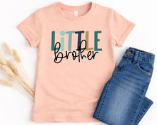 Load image into Gallery viewer, A pink t-shirt with the text "Little brother" printed on it, along with a pair of blue jeans.