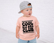 Load image into Gallery viewer, A young child wearing a gray cap and a pink t-shirt with the text "COOL BIG BRO CLUB" printed on it.