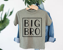 Load image into Gallery viewer, A gray t-shirt with the text "BIG BRO" printed on it, hanging on a clothing hanger.