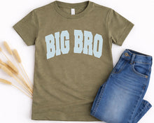 Load image into Gallery viewer, A green t-shirt with the text "BIG BRO" printed on it, along with a pair of blue jeans, are laid out on a white background.