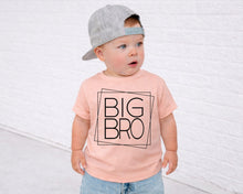 Load image into Gallery viewer, A young child wearing a gray cap and a pink t-shirt with the text "BIG BRO" printed on it, standing in front of a white brick wall.