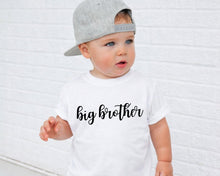 Load image into Gallery viewer, A young child wearing a white t-shirt with the text "big brother" printed on it, standing in front of a white brick wall.