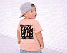 Load image into Gallery viewer, A young child wearing a gray cap and a pink t-shirt with the text "Cool Big Bro Club" printed on the back.