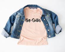 Load image into Gallery viewer, A denim jacket and a pink t-shirt with the text "Big Sister" printed on it, laid out on a white background.