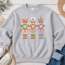Load image into Gallery viewer, Pastel Nutcrackers Christmas design on Ash Grey crewneck sweatshirt