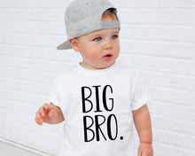 Load image into Gallery viewer, A young child wearing a white t-shirt with the text "BIG BRO." printed on it, standing in front of a white brick wall.
