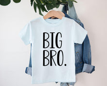 Load image into Gallery viewer, A white t-shirt with the text "BIG BRO" printed on it, hanging on a clothing hanger.
