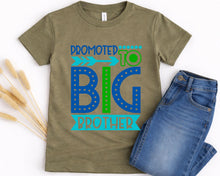 Load image into Gallery viewer, A t-shirt with a graphic design that says "Promoted to Big Brother" and a pair of blue jeans are placed on a white background.
