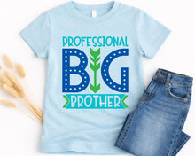Load image into Gallery viewer, A light blue t-shirt with a graphic design that says "Professional Big Brother" in blue and green text, along with a green arrow pointing to the word "Brother". Next to the t-shirt is a pair of blue jeans.

