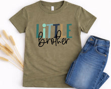 Load image into Gallery viewer, A green t-shirt with the text "Little brother" printed on it, along with a pair of blue jeans.
