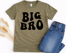 Load image into Gallery viewer, A green t-shirt with the text "BIG BRO" printed on it, along with a pair of blue jeans.
