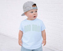 Load image into Gallery viewer, A young child wearing a gray baseball cap and a light blue t-shirt with the text "BIG BRO" standing in front of a white brick wall.
