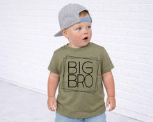 Load image into Gallery viewer, A young child wearing a gray baseball cap and a green t-shirt with the text "BIG BRO" printed on it, standing in front of a white brick wall.
