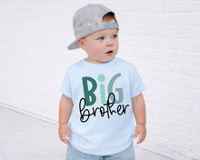 Load image into Gallery viewer, A young child wearing a gray baseball cap and a light blue t-shirt with the text "BIG brother" printed on it, standing in front of a white brick wall.
