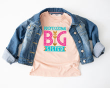 Load image into Gallery viewer, a pink t-shirt with the text "DPOPROFESSIONAL BIG SISTER" printed on it, along with a denim jacket.
