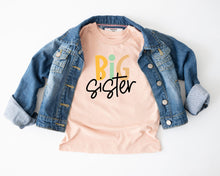 Load image into Gallery viewer, a casual outfit consisting of a denim jacket and a pink t-shirt with the text "BIG SISTER" printed on it.
