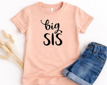 Load image into Gallery viewer, A pink t-shirt with the text "big SIS" printed on it, along with a pair of blue jeans, are laid out on a white background.
