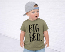 Load image into Gallery viewer, A young child wearing a green t-shirt with the text "BIG BRO" printed on it, standing in front of a white brick wall.
