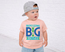 Load image into Gallery viewer, A young child wearing a gray baseball cap and a pink t-shirt with the text "Professional Big Brother" printed on it.
