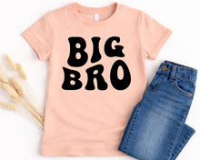 Load image into Gallery viewer, A pink t-shirt with the text "BIG BRO" printed on it, along with a pair of blue jeans, are displayed on a white background.
