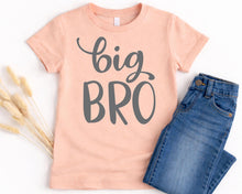 Load image into Gallery viewer, A pink t-shirt with the text "BIG BRO" printed on it, along with a pair of blue jeans, are laid out on a white background.
