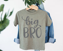 Load image into Gallery viewer, A gray t-shirt with the text "big BRO" printed on it, hanging on a wooden hanger.
