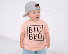 Load image into Gallery viewer, A young child wearing a gray cap and a pink t-shirt with the text "BIG BRO" printed on it, standing in front of a white brick wall.
