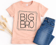 Load image into Gallery viewer, A pink t-shirt with the text "BIG BRO" printed on it, along with a pair of blue jeans, are displayed on a white background.
