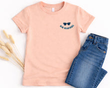 Load image into Gallery viewer, A pink t-shirt with a graphic design and the text "BIG BROTHER" printed on it, along with a pair of blue jeans, are laid out on a white background.
