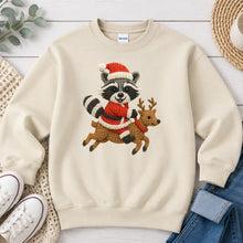 Load image into Gallery viewer, Raccoon Riding Reindeer Christmas design on Sand crewneck sweatshirt
